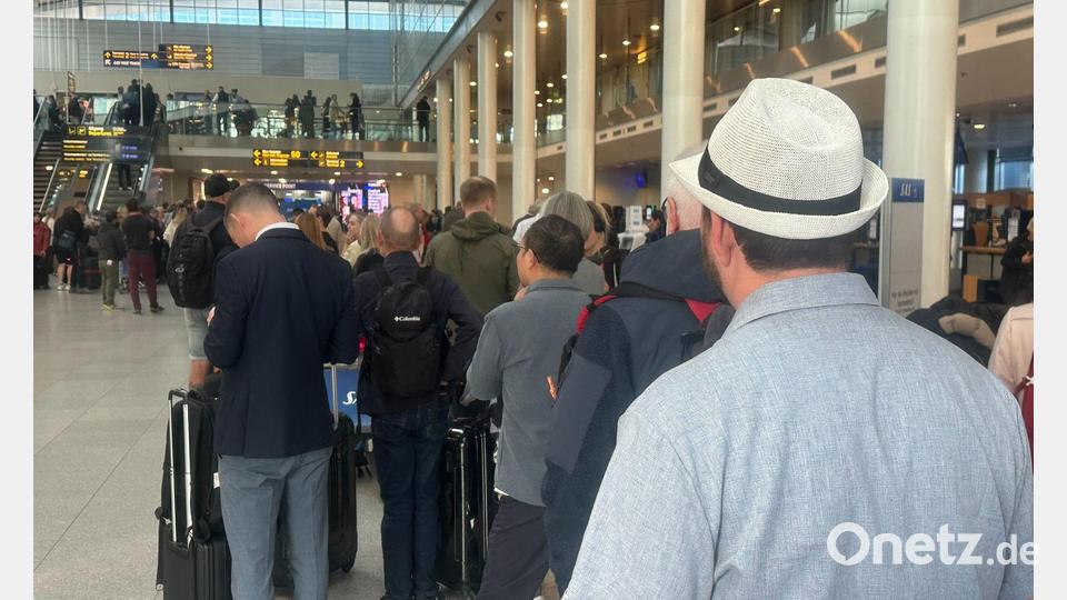 An einem Serviceschalter am Flughafen bildete sich eine lange Warteschlange. Bild: Steffen Trumpf/dpa