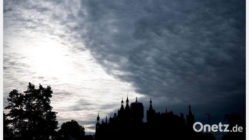 Düstere Kulisse: Dunkle Wolken ziehen über das Schweriner Schloss. Bild: Daniel Bockwoldt/dpa