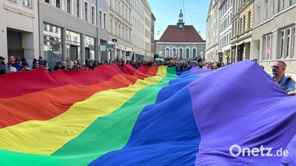 Teilnehmer ziehen mit einer überdimensionalen Regenbogenfahne beim 4. Christopher Street Day (CSD) durch die Stadt. Bild: Danilo Dittrich/dpa