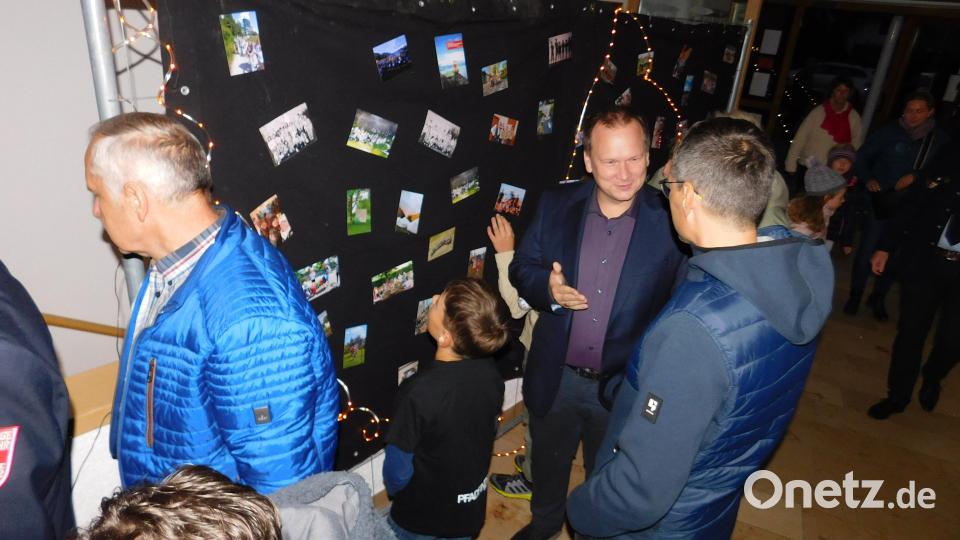 Auf einer Bildertafel im Foyer wurden die Gäste, darunter Bürgermeister Christian Porsch (Mitte), mit auf eine Reise durch 35 Jahre Pfadfindergeschichte genommen. Bild: whü