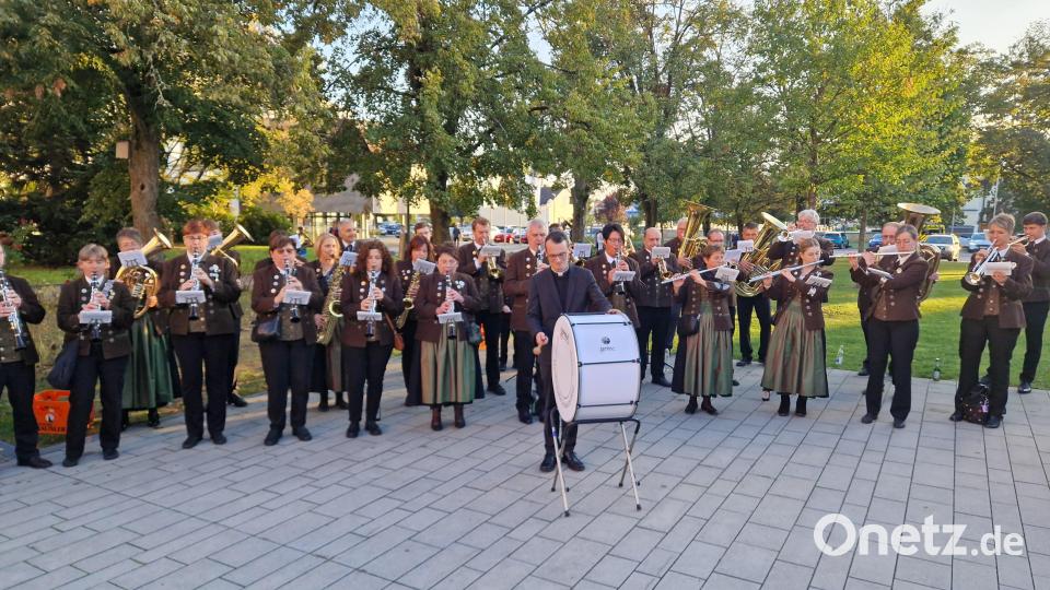 Das Musizieren mit der Blaskapelle hat Pfarrer Moosbauer sichtlich Freude bereitet. Mit der großen Trommel gibt er den Takt vor. Bild: mab