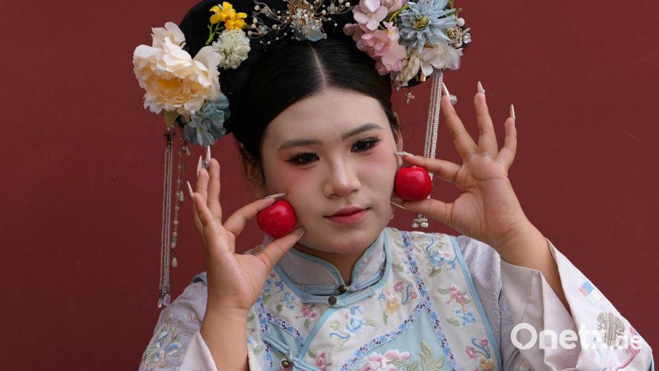 Peking: Frau in traditioneller Tracht feiert Nationalfeiertag vor der Verbotenen Stadt Bild: Ng Han Guan/AP/dpa