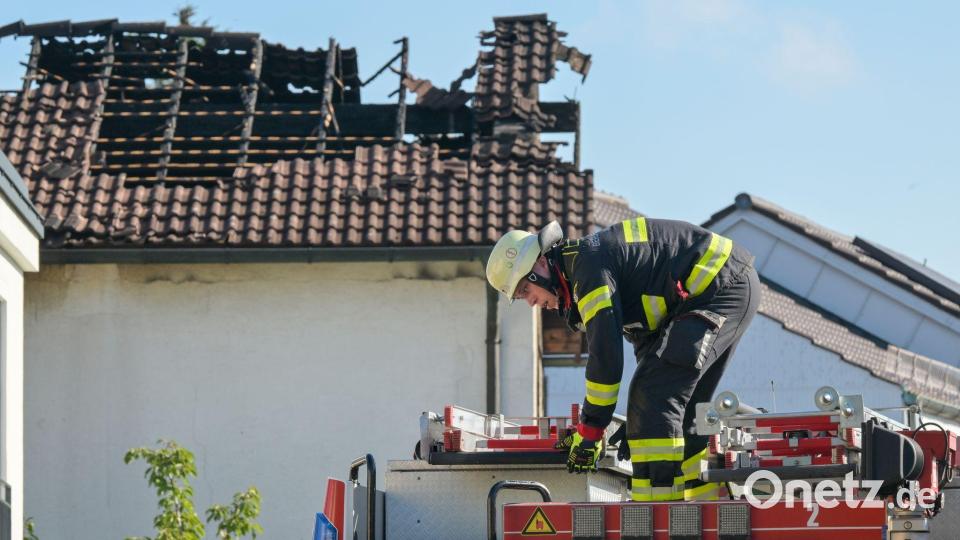 Nach Brand in München: Feuerwehrleute packen an einem Haus im Münchner Norden ihre Utensilien ein. Bild: Peter Kneffel/dpa