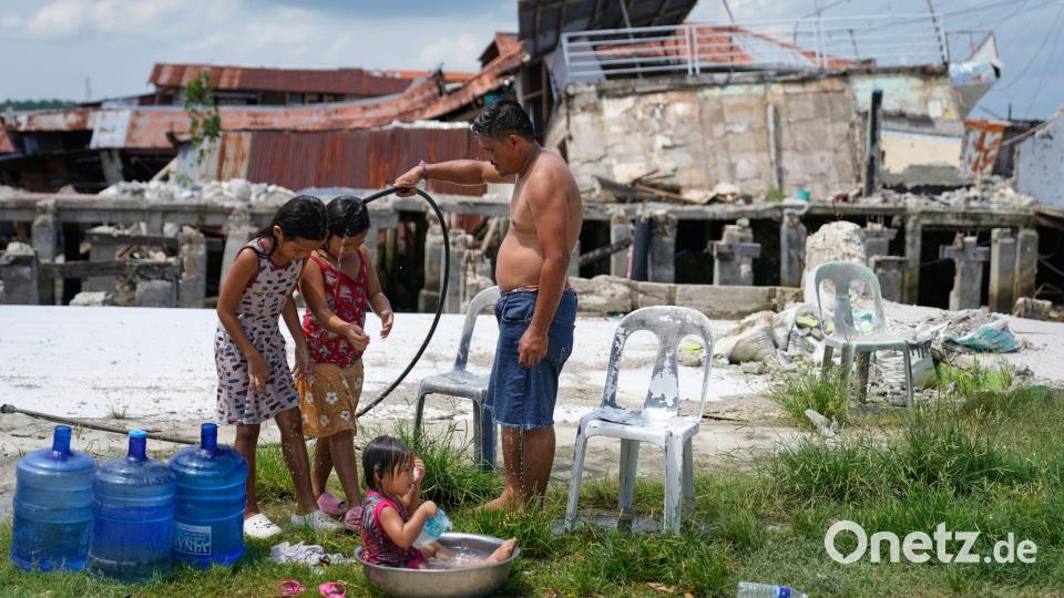 Erdbeben in Bogo: Vater badet mit Töchtern neben Ruinen Bild: Aaron Favila/AP/dpa