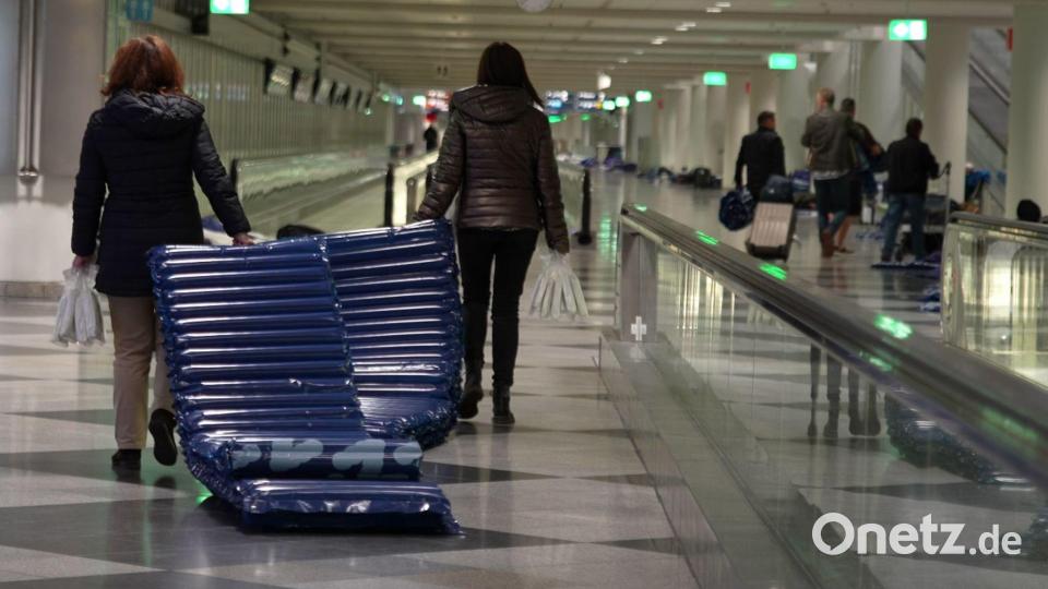 Menschen tragen nach möglichen Drohnensichtungen am Flughafen München Luftmatratzen. Bild: Enrique Kaczor/onw-images/dpa