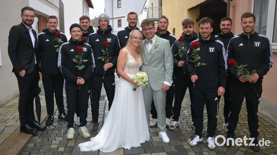 Inmitten der Fußballer des TSV Konnersreuth suchte sich das Brautpaar Monja Schiml und Marco Rogler einen Platz, die sich sehr über das Ehrenspalier freuten. Links TSV-Vorsitzender Maximilian Siller. Bild: jr