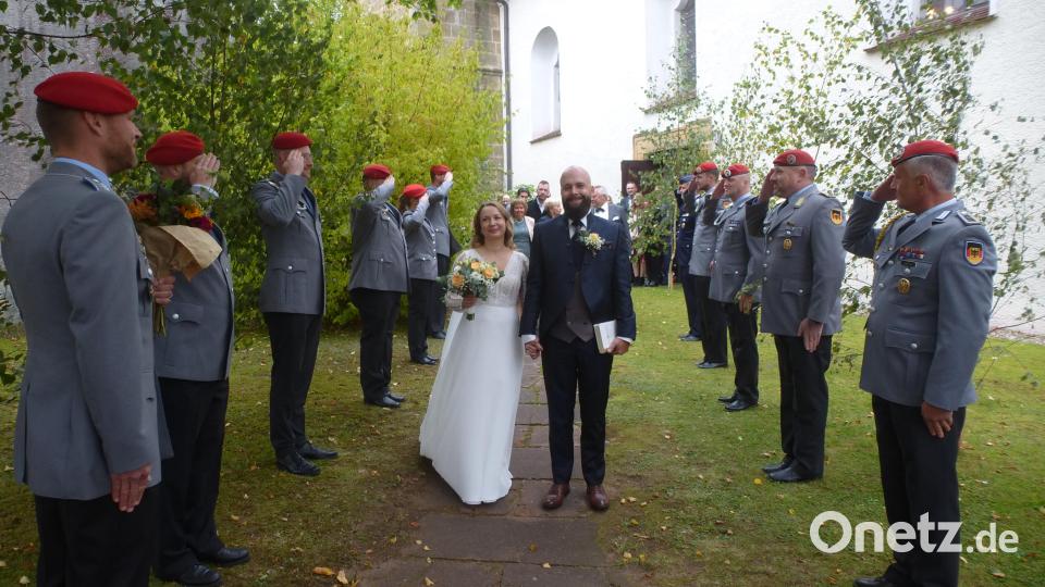 Karolina Diebel und Patrick Müller laufen vor der Martinskirche in Kaltenbrunn durch das Ehrenspalier der Bundeswehr. Hauptmann Marco Thalmann (links) gratuliert mit einem Blumenstrauß. Bild: bk