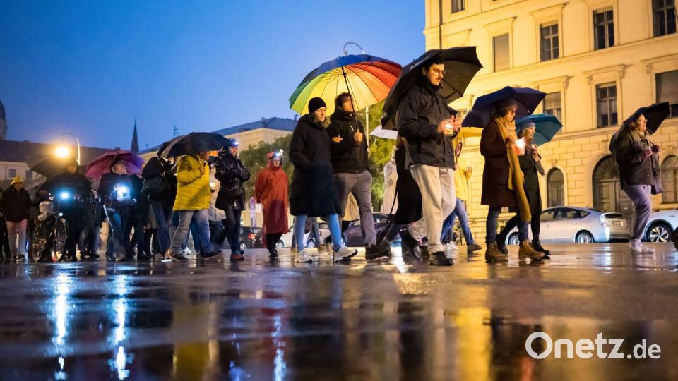 Teilnehmer des Schweigemarschs &quot;Mach Dich auf für Menschlichkeit!&quot; gehen mit Kerzen auf der Ludwigsstraße in München. Bild: Tobias Hase/dpa