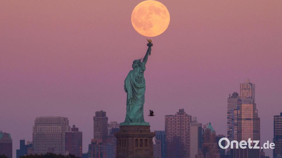 Der Supermond geht hinter der Freiheitsstatue in New York auf. Bild: Adam Gray/AP/dpa