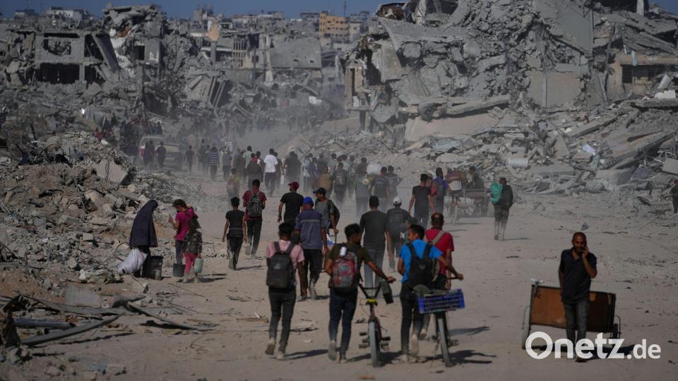 Palästinenser gehen an zerstörten Gebäuden vorbei, während sie in ihre Häuser im Zeitoun-Viertel von Gaza zurückkehren. Bild: Jehad Alshrafi/AP/dpa