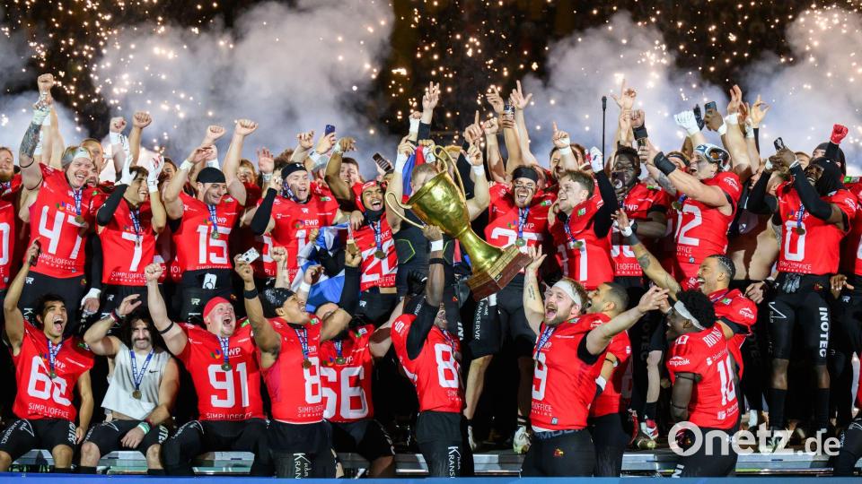 Die Potsdam Royals werden in Dresden Deutscher Meister im American Football und jubeln mit dem Pokal. Bild: Robert Michael/dpa