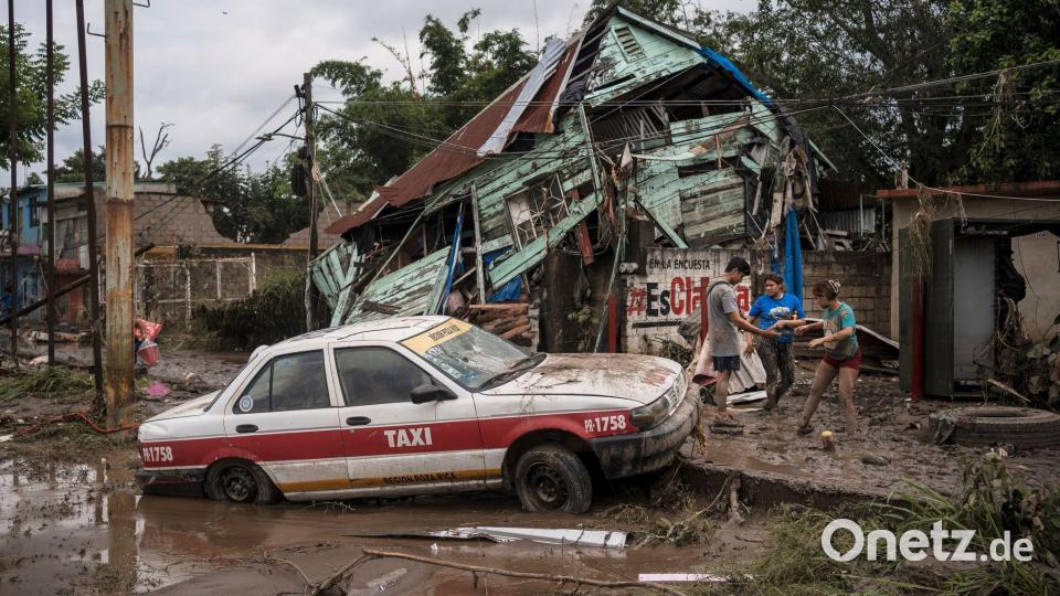 Häuser wurden beschädigt, Autos mit der Strömung wegschwemmt. Bild: Felix Marquez/AP/dpa