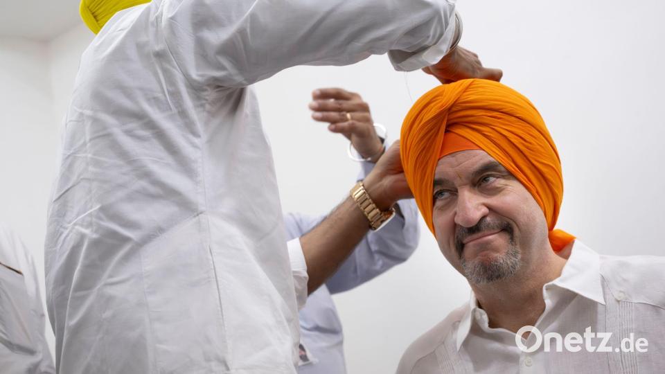 Beim Auslandsbesuch in Indien lässt sich Söder einen Turban anlegen - ein perfektes Fotomotiv für die sozialen Netzwerke. (Archivbild) Bild: Peter Kneffel/dpa