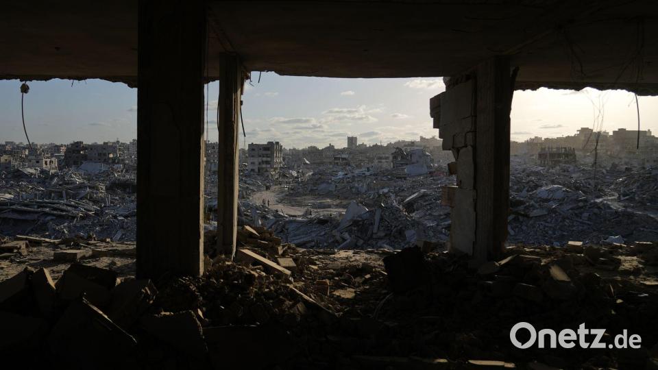 Palästinenser gehen zwischen den Trümmern der Stadt Gaza. Bild: Abdel Kareem Hana/AP/dpa