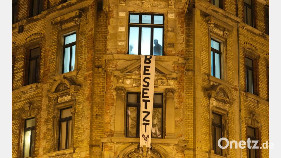 Polizisten sind in einem leerstehenden Haus im Leipziger Osten, an dessen Fassade ein Transparent mit der Aufschrift „Besetzt“ häng Bild: Sebastian Willnow/dpa