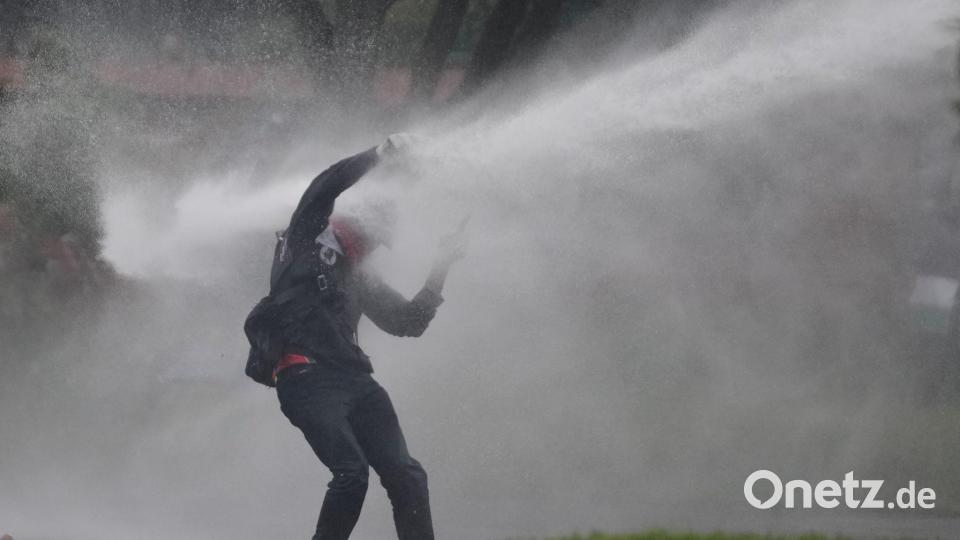 Mit voller Wucht: Ein Demonstrant wird bei Protesten gegen die Politik von Präsident Petro von einem Wasserwerfer getroffen. Bild: Fernando Vergara/AP/dpa