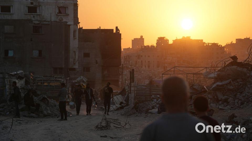 Palästinenser gehen in Gaza-Stadt an Häusern vorbei, die durch die israelische Luft- und Bodenoffensive zerstört wurden. Bild: Abdel Kareem Hana/AP/dpa