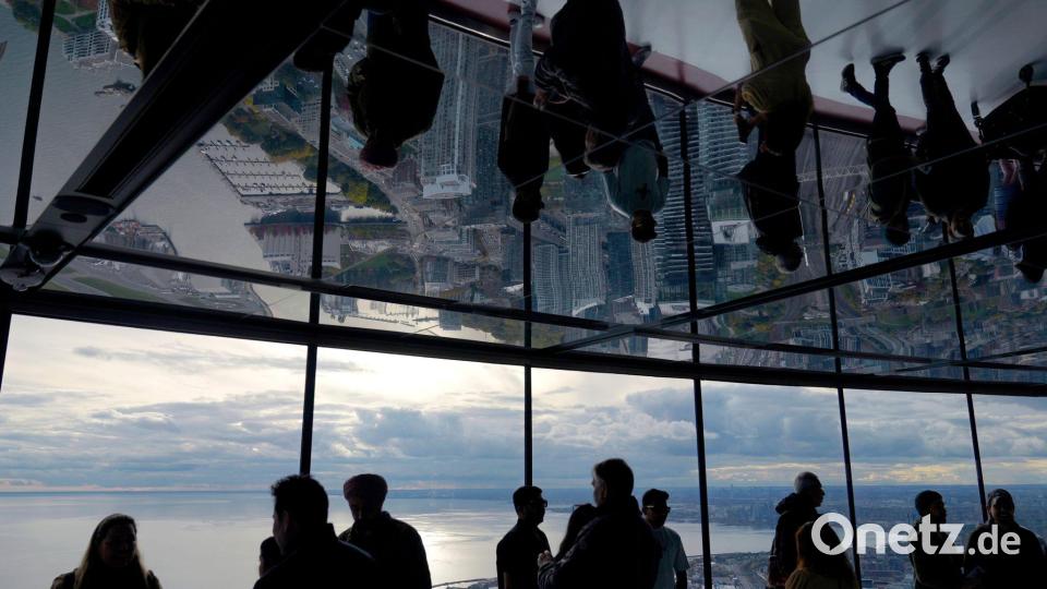 Menschen schauen vom CN Tower in Toronto auf das Rogers Centre und den Ontariosee. Bild: Brynn Anderson/AP/dpa