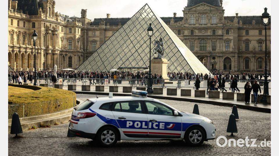 Ein Polizeiauto parkt im Hof des Louvre. Eine Woche nach dem spektakulären Kunstraub im Pariser Louvre hat es zwei Festnahmen gegeben. Bild: Thomas Padilla/AP/dpa
