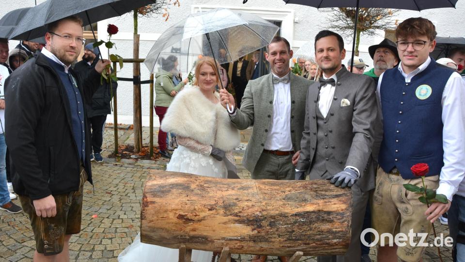 Lea Schatzberger und Marco Zeitler (mit Handschuhen) freuten sich über die Glückwünsche des Pechbrunner Burschenvereins. Am vorbereiteten Baumstamm mussten sie ihr Geschick beim Sägen beweisen. Trotz Nieselregen meisterten sie auch diese Hürde. Bild: jr