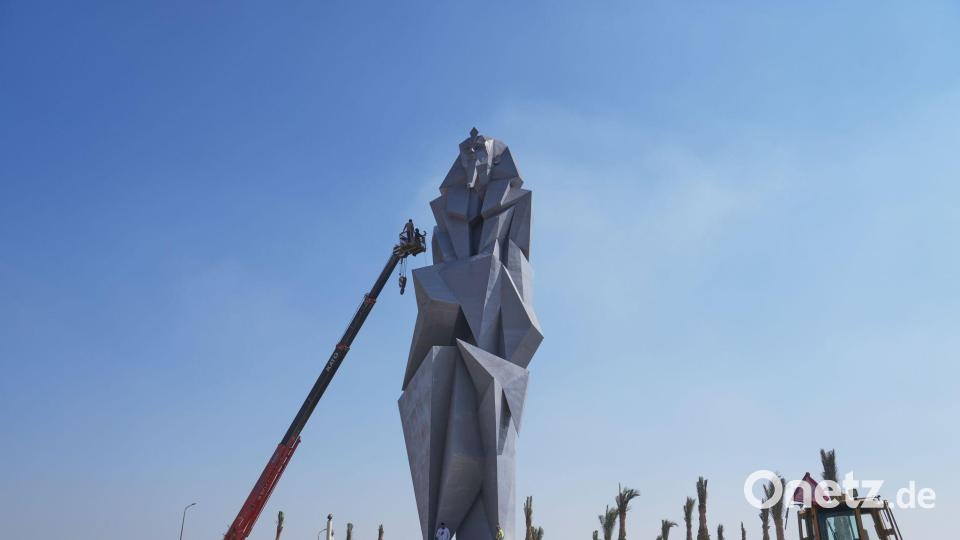 Arbeiter bemalen die 27 Meter hohe Eisenstatue "The Guard" des ägyptischen Künstlers Deyaa Awed. Die Statue steht den Besuchern gegenübersteht, die vom Flughafen Sphinx zum Großen Ägyptischen Museum kommen. Bild: Amr Nabil/AP/dpa