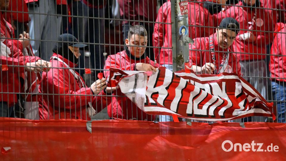Leipzigs Fans nehmen zu Beginn der zweiten Halbzeit die Fahnen ab. Vor Beginn des Spiels war ein Fan vor dem Stadion verstorben. Bild: Robert Michael/dpa