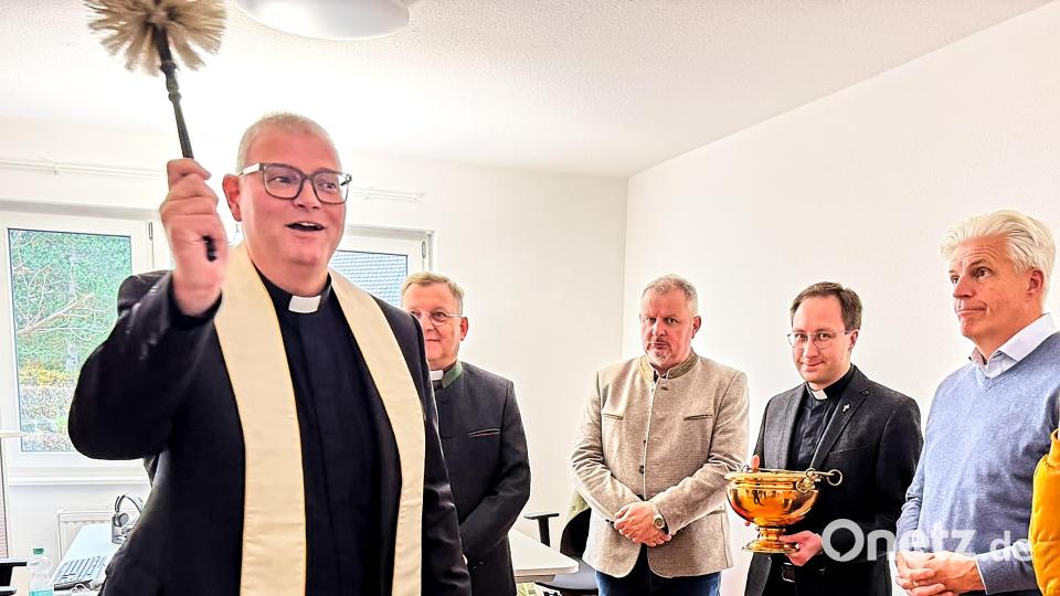Domkapitular Johann Ammer vollzieht die Einweihung des Dienstleistungszentrums des Bistums Regensburg mit Weihwasser, im Vordergrund, von links weiter: Regionaldekan und Stadtpfarrer Markus Brunner, Architekt Heinrich Schwirzer, Kaplan Johannes Spindler und der Kirchenpfleger von St. Georg, Martin Ströhl. Bild: Peter Ringeisen