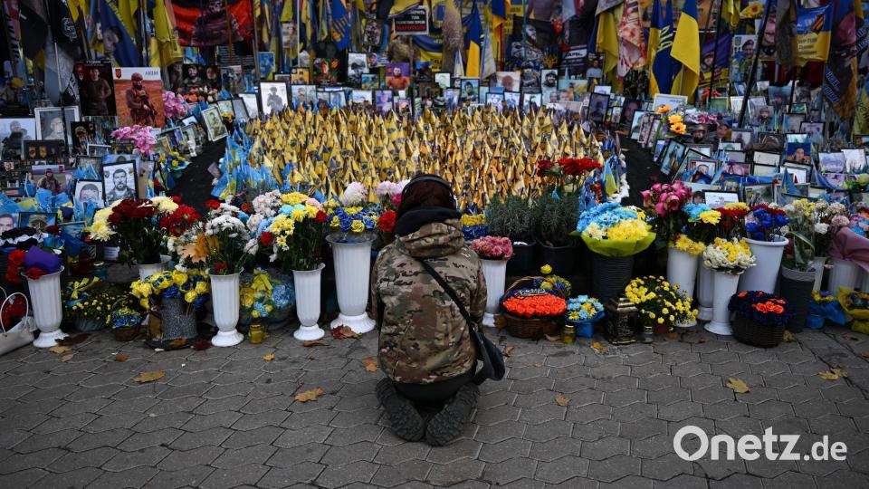 Eine junge Frau kniet am Unabhängigkeitsplatz Maidan in Kiew. Hier wird den Gefallenen des Krieges gedacht. Bild: Hendrik Schmidt/dpa