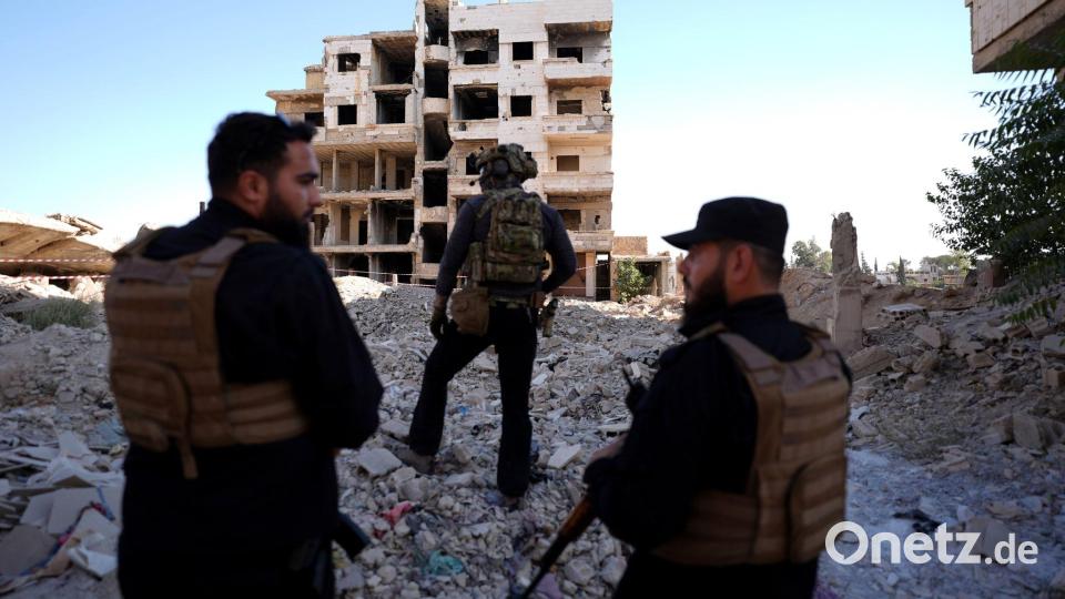 Sicherheitskräfte aus Syrien und aus Deutschland sichern den Besuch von Außenminister Wadephul bei einem humanitären Projekt in einer Straße mit während des Bürgerkriegs zerbombten Häusern in Harasta ab. Bild: Marcus Brandt/dpa