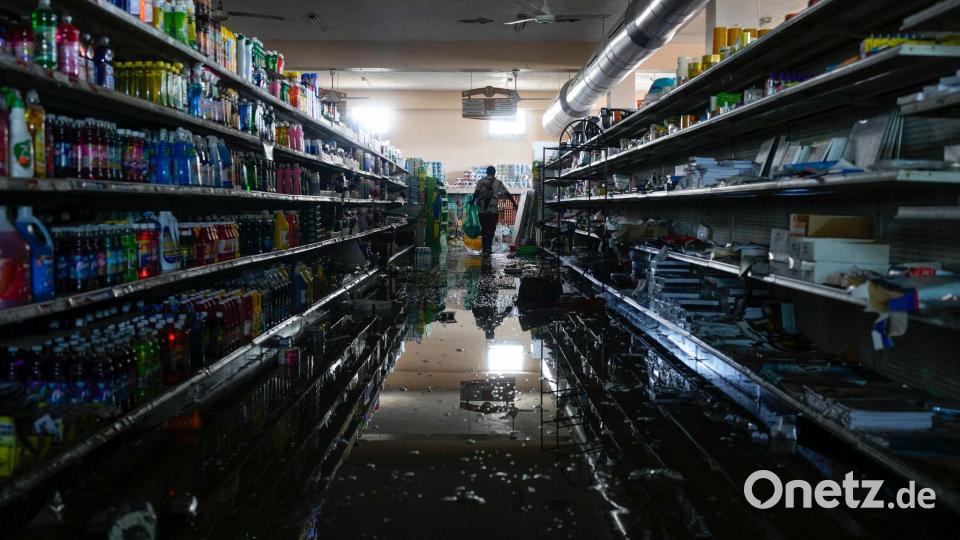 Mit der Erlaubnis des Supermarktbesitzers versorgt sich eine Person in Black River auf Jamaika nach dem Durchzug des Hurrikans „Melissa“ mit Vorräten und Lebensmitteln. Bild: Matias Delacroix/AP/dpa