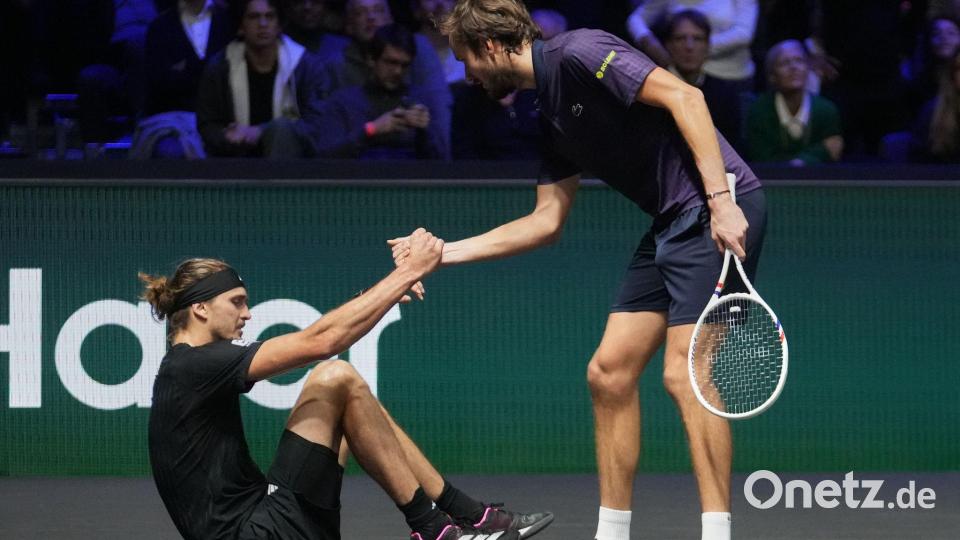 Daniil Medwedew hilft Alexander Zverev (l) nach einem Sturz auf. Bild: Michel Euler/AP/dpa