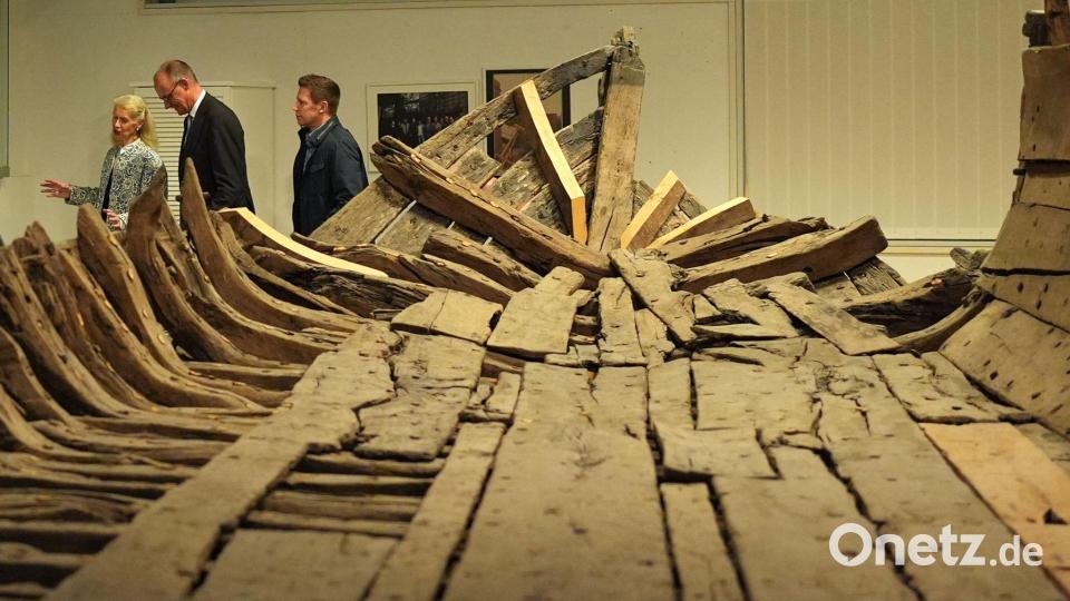 Bundeskanzler Friedrich Merz (2.v.l, CDU) geht mit Museumsdirektorin Astrid Cohrs-Dreessen (l) nach einer Pressekonferenz im Schifffahrtsmuseum Nordfriesland an dem „Zuckerschiff“ vorbei. Bild: Marcus Brandt/dpa
