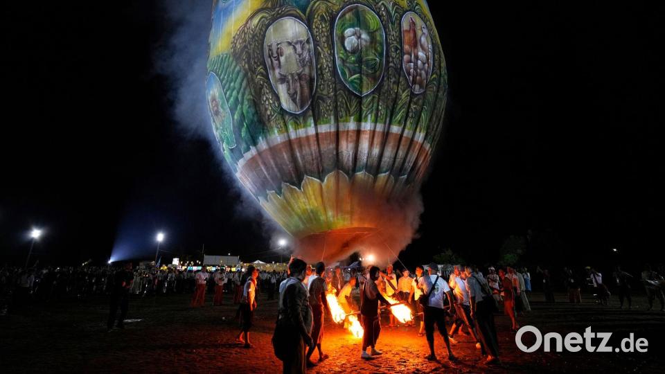 Menschen bereiten sich auf den Start eines Heißluftballons während eines Wettbewerbs anlässlich des Tazaungdaing-Fests in Naypyitaw in Myanmar vor. Bild: Aung Shine Oo/AP/dpa