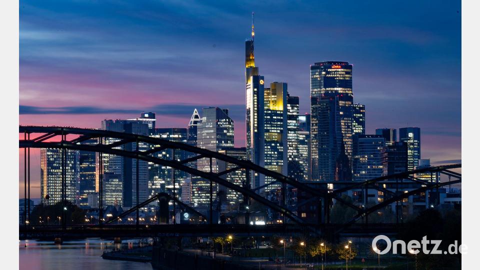 Die Lichter der Bankenskyline von Frankfurt leuchten in der Abendstimmung. Bild: Boris Roessler/dpa