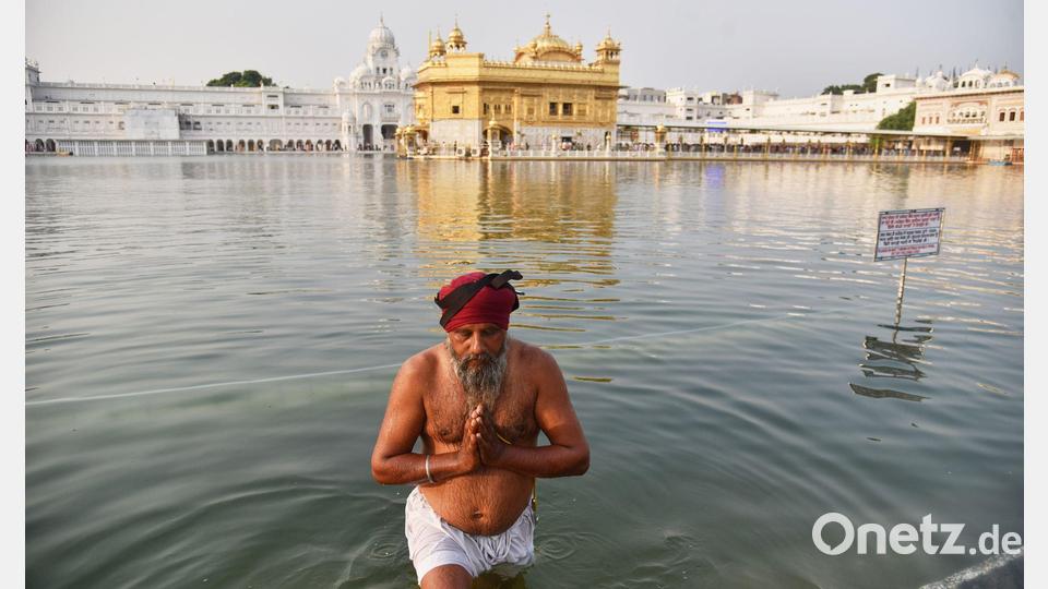 Feiertag Guru Nanak Jayanti: Sikh-Anhänger nimmt ein heiliges Bad im Goldenen Tempel. Bild: Prabhjot Gill/AP/dpa
