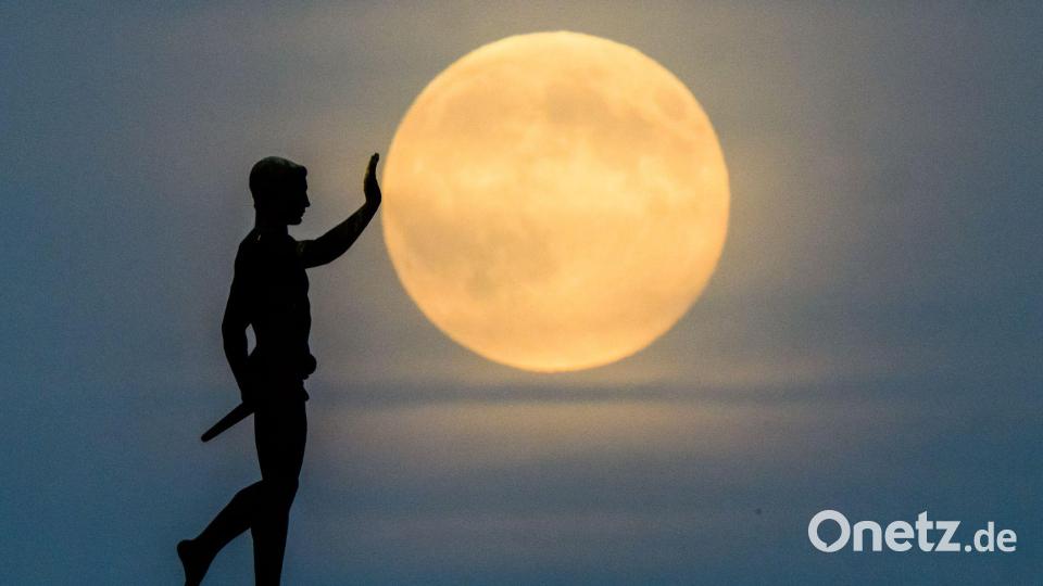 Der "Fackelträger" aus Hannover schiebt den Mond an.... Bild: Julian Stratenschulte/dpa