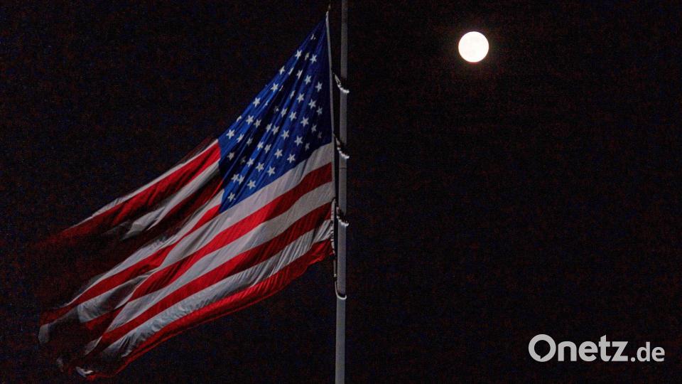 Der Vollmond geht hinter der auf Halbmast stehenden amerikanischen Flagge auf dem Südrasen des Weißen Hauses auf. Bild: Allison Robbert/AP/dpa