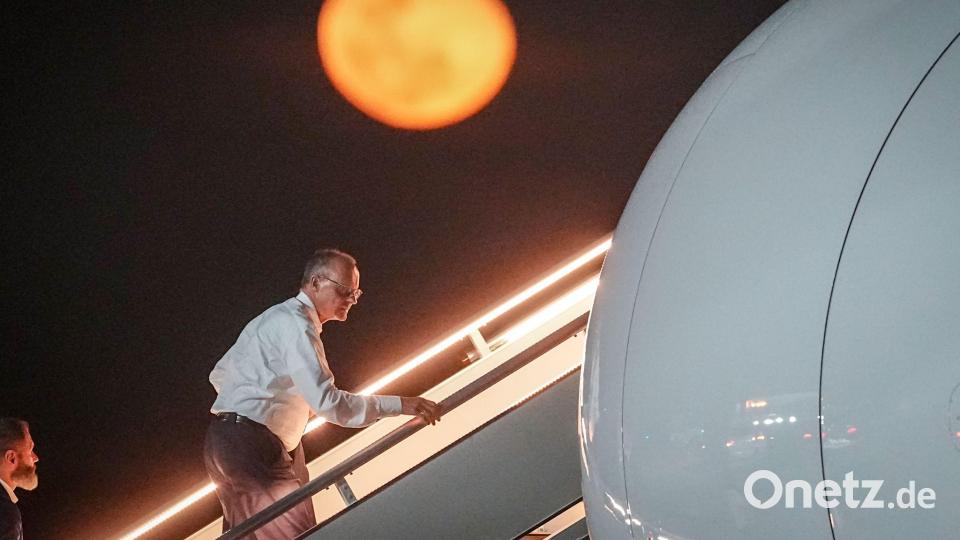 Bundeskanzler Friedrich Merz geht die Gangway vor dem aufgehenden Mond hinauf. Bild: Kay Nietfeld/dpa