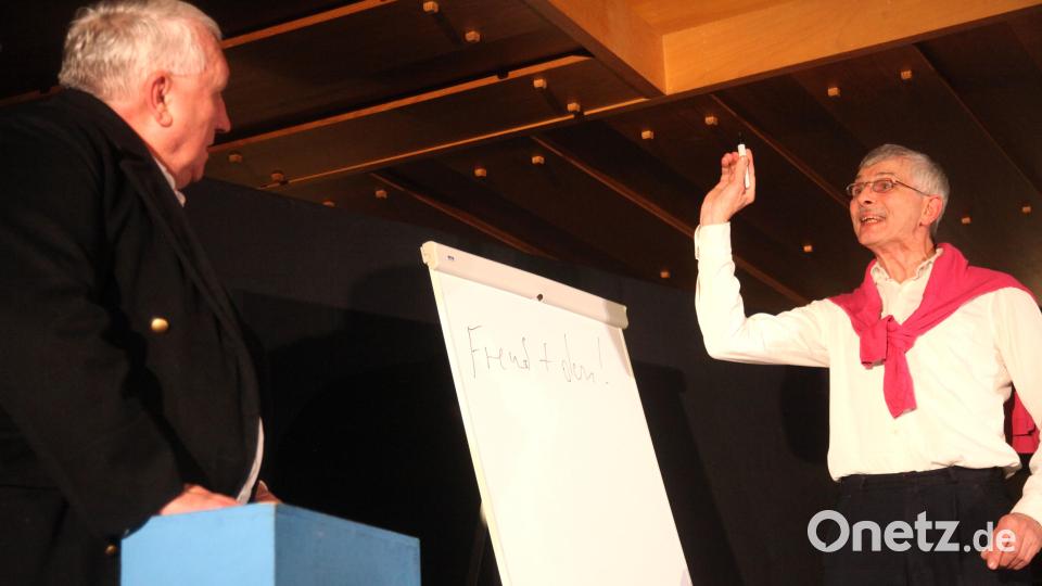 Karl Valentin, alias Josef Götz (rechts), veranschaulicht an der Tafel: „Wenn ein Zug unter einer Brücke hindurchfährt, über die gerade Leute gehen, „dann sind Fremde unter Fremden“. Bild: Hirsch