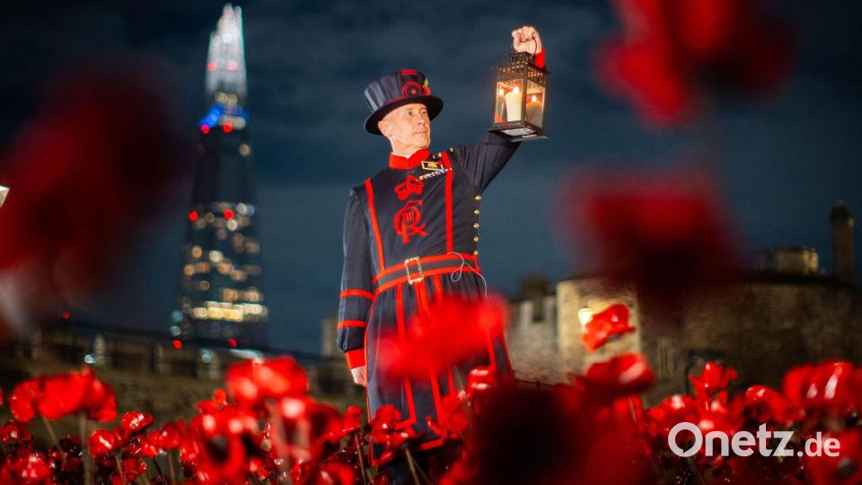Ein Yeoman Warder (Beefeater) des Tower of London hält eine Laterne bei einer Ausstellung von Keramik-Mohnblumen im Tower anlässlich des Armistice Day. Bild: James Manning/PA Wire/dpa