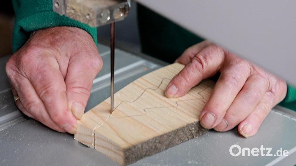 Robert Steinkohl sägt in seiner Werkstatt mit der Bandsäge kleine Weihnachtsbäume aus. Bild: rw