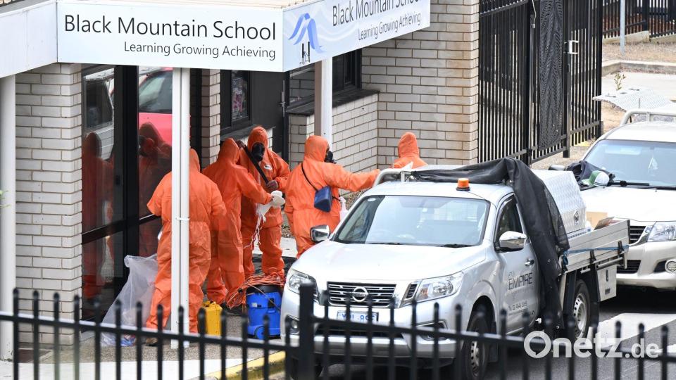 In Schutzanzügen wurden die Schulen gesäubert und der Sand entsorgt. Bild: Lukas Coch/AAP/dpa