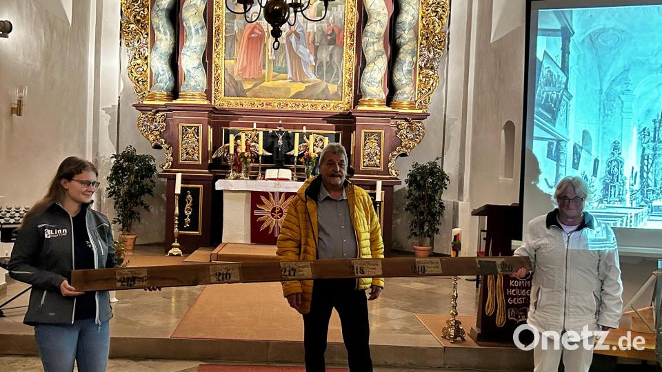 Ortsheimatpfleger Horst Pirner übergibt Anna-Maria Trautmann (links) und Anita Dehling (rechts) ein Stück von einer Frauenbank aus dem Jahre 1815. Bild: hdk