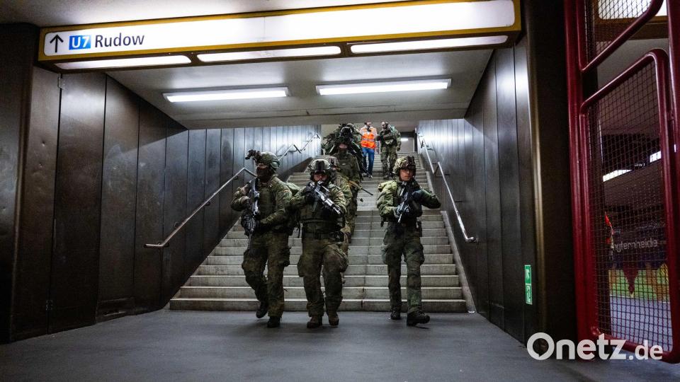 Bundeswehrsoldaten laufen bei einer Übung eine Treppe im U-Bahnhof Jungfernheide in Berlin herunter. Bild: Christophe Gateau/dpa