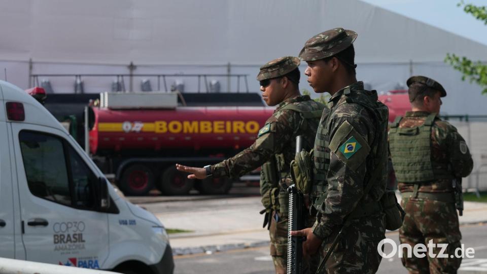 Sicherheitskräfte leiten Fahrzeuge nach einem Brand auf dem Gelände der Weltklimakonferenz. Bild: Fernando Llano/AP/dpa