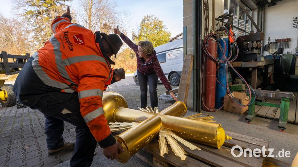 Kunstschmiedin Andrea Würzinger soll die dicke Schicht Aufkleber entfernen, den Untergrund schleifen sowie Lack und neues Blattgold aufbringen. Bild: Peter Kneffel/dpa