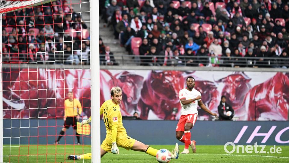 Bremens Torwart Mio Backhaus (l, Werder Bremen) und Ridle Baku (RB Leipzig) schauen dem Ball hinterher. Backhaus verhinderte mit seinen Paraden einen frühen Rückstand der Gäste in Leipzig. Bild: Jennifer Brückner/dpa