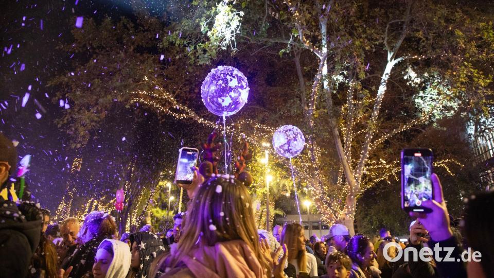 Menschen nehmen an der Einschaltung der Weihnachtsbeleuchtung in Palma auf Mallorca teil. Bild: Clara Margais/dpa