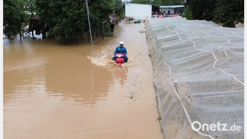 Mann kämpft sich auf überfluteter Straße durch die Fluten in Zentralvietnam Bild: --/VNA/XinHua/dpa