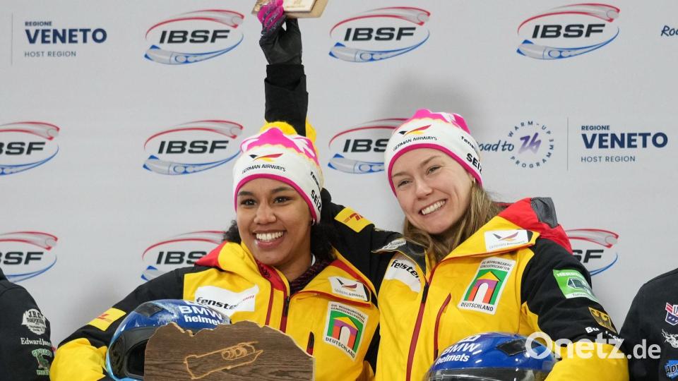 Laura Nolte und Deborah Levi jubeln auf dem Podium nach Zweierbob-Sieg in Cortina Bild: Andrew Medichini/AP/dpa